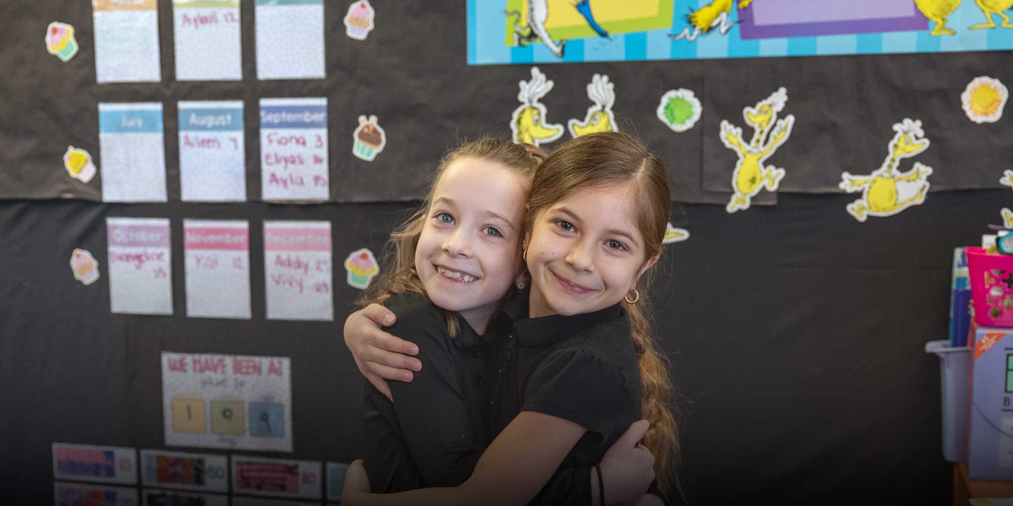 Two students standing in front of bulletin board